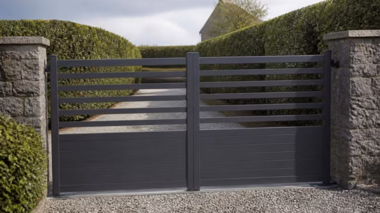 Double aluminium swing gates between stone pillars
