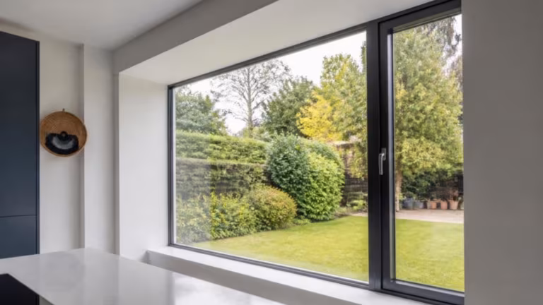 Kitchen extension with large anthracite aluminium windows looking onto a garden