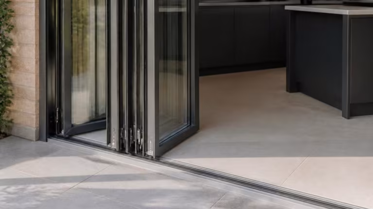Bifold doors partly folded showing a low threshold to the patio