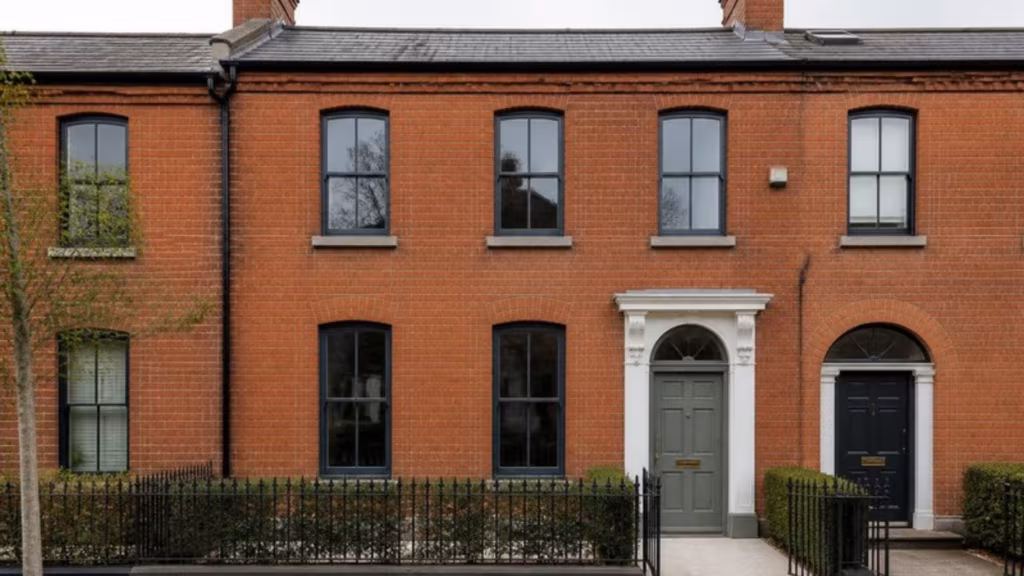 Red-brick terraced house with slim black aluminium windows with glazing bars