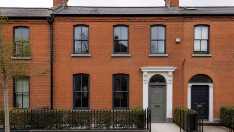 Red-brick terraced house with slim black aluminium windows with glazing bars