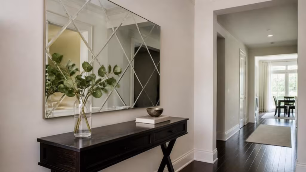Etched geometric pattern mirror above a hallway console table