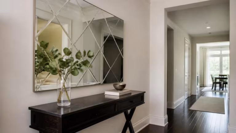 Etched geometric pattern mirror above a hallway console table