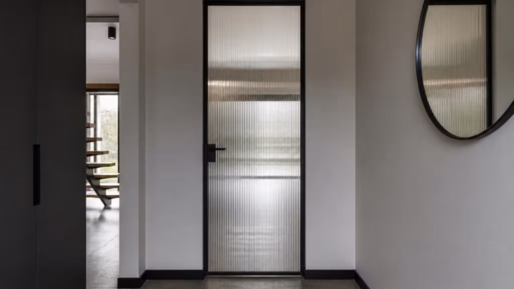 Fluted glass internal door in a black frame in a hallway