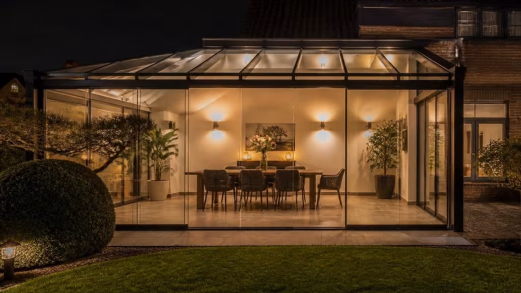 Veranda with frameless glass walls lit up at night