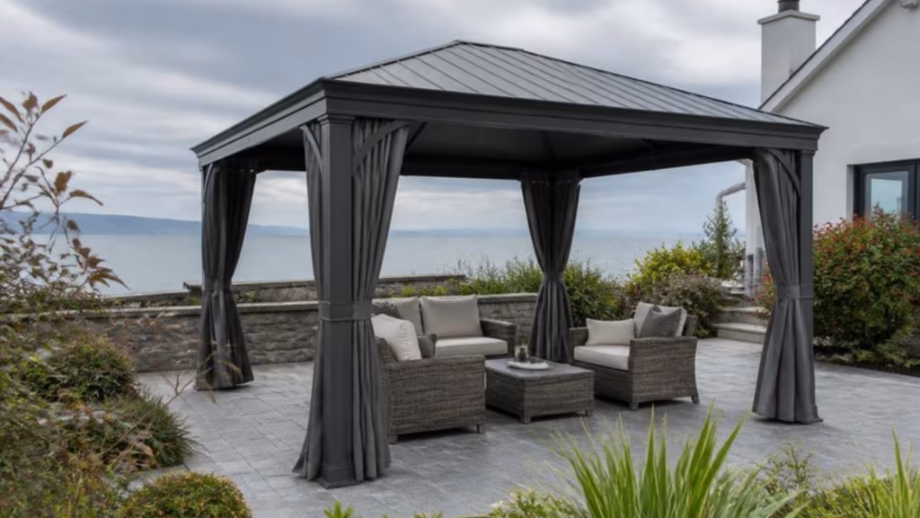 Aluminium gazebo with side curtains in a garden overlooking the sea