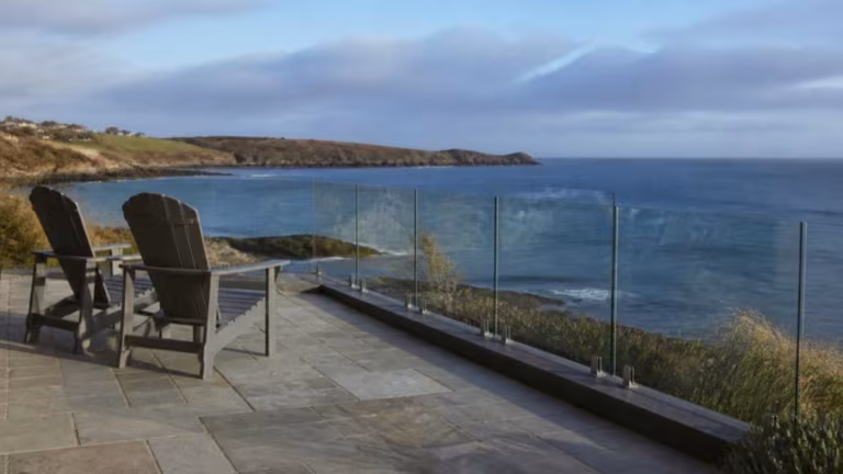 Frameless glass fence around a patio overlooking the sea