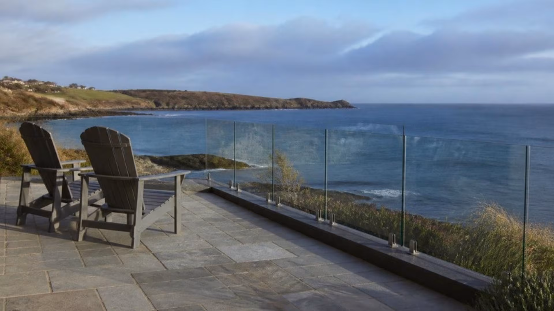 Frameless glass fence around a patio overlooking the sea