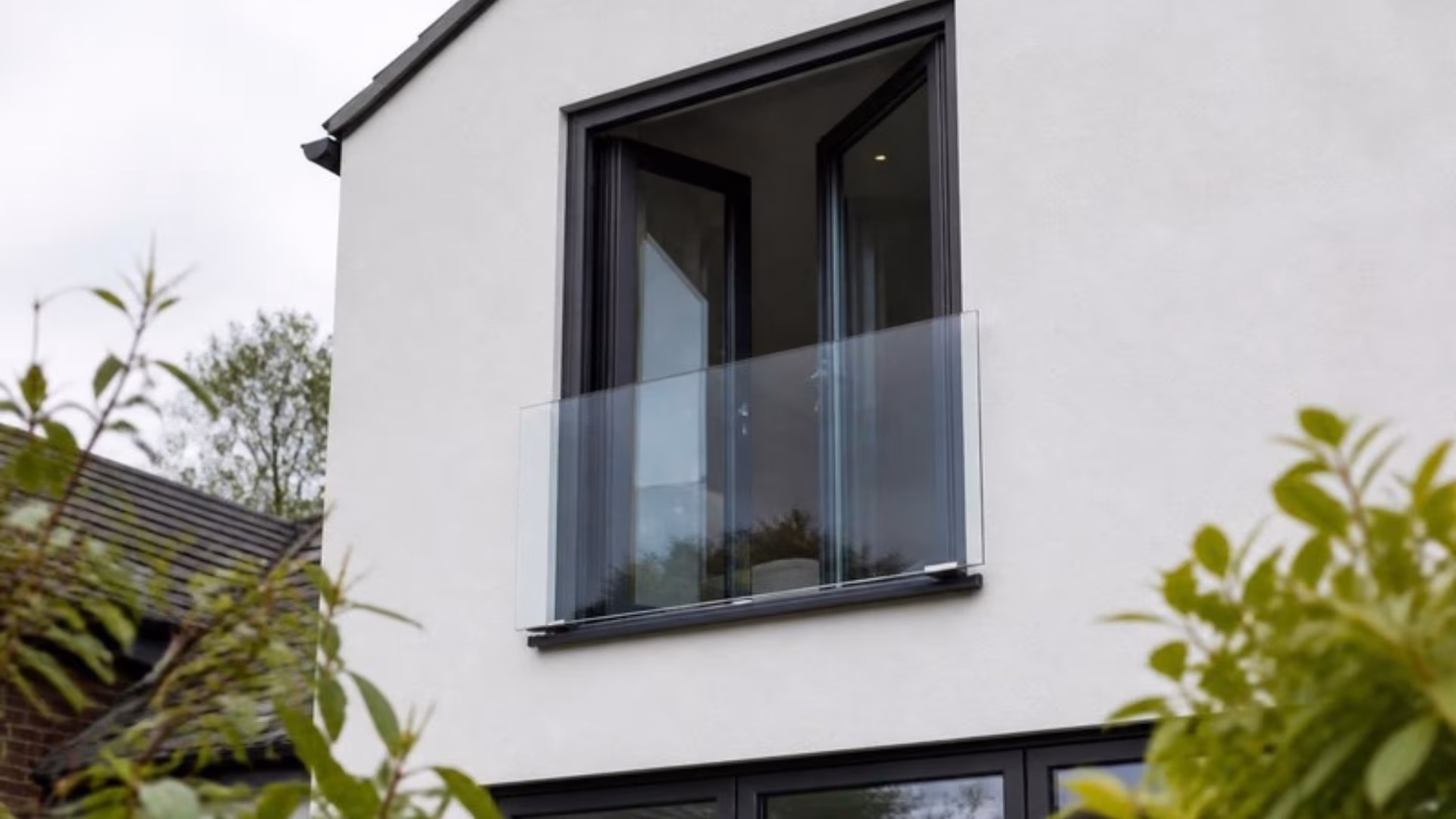 Frameless glass Juliet balcony across first-floor French doors
