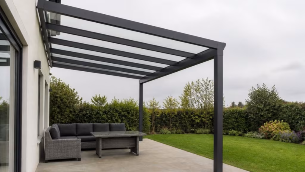Aluminium veranda with a clear glass roof over a garden patio