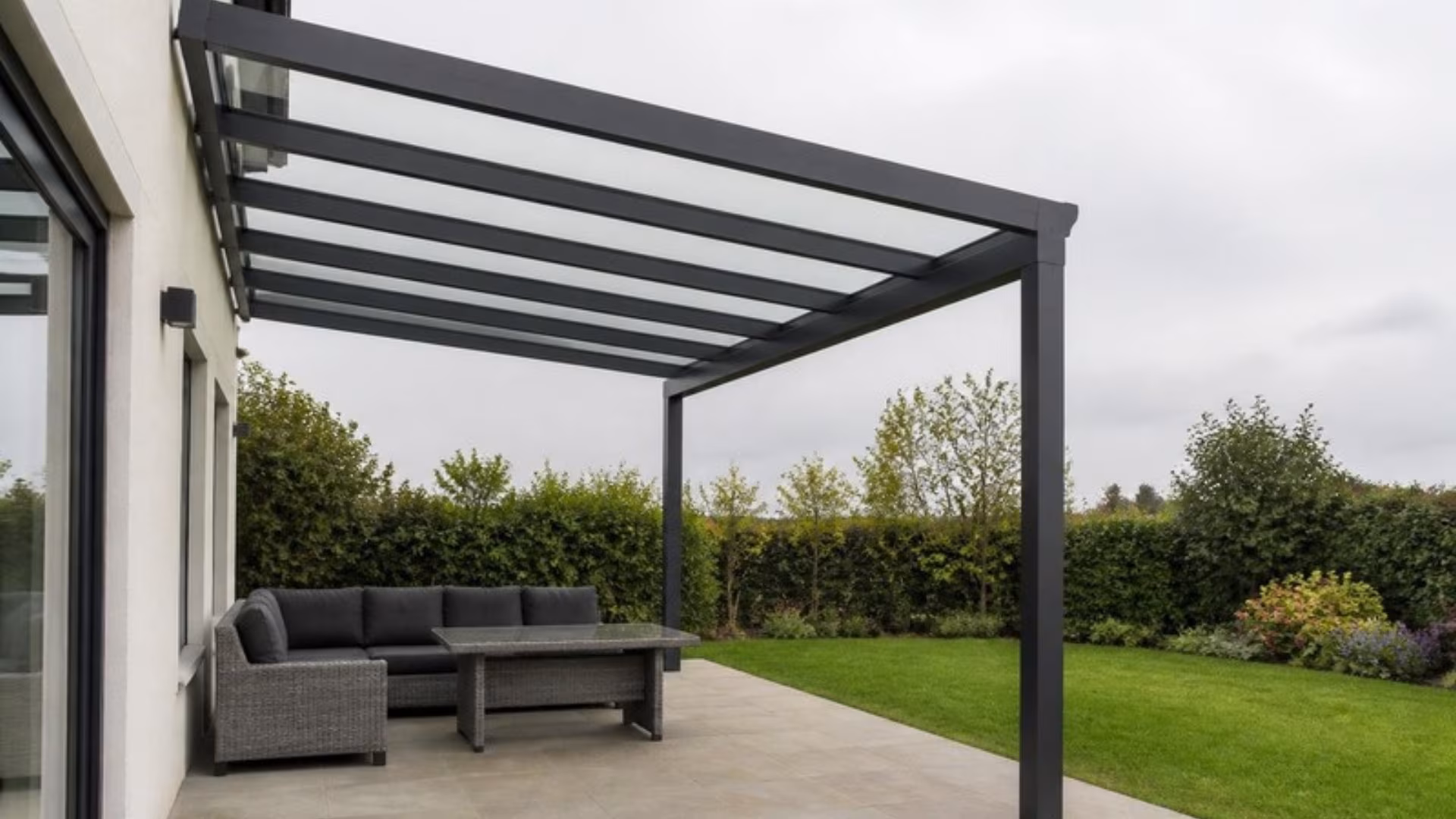 Aluminium veranda with a clear glass roof over a garden patio
