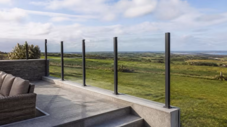 Glass windbreak with aluminium posts on a raised patio