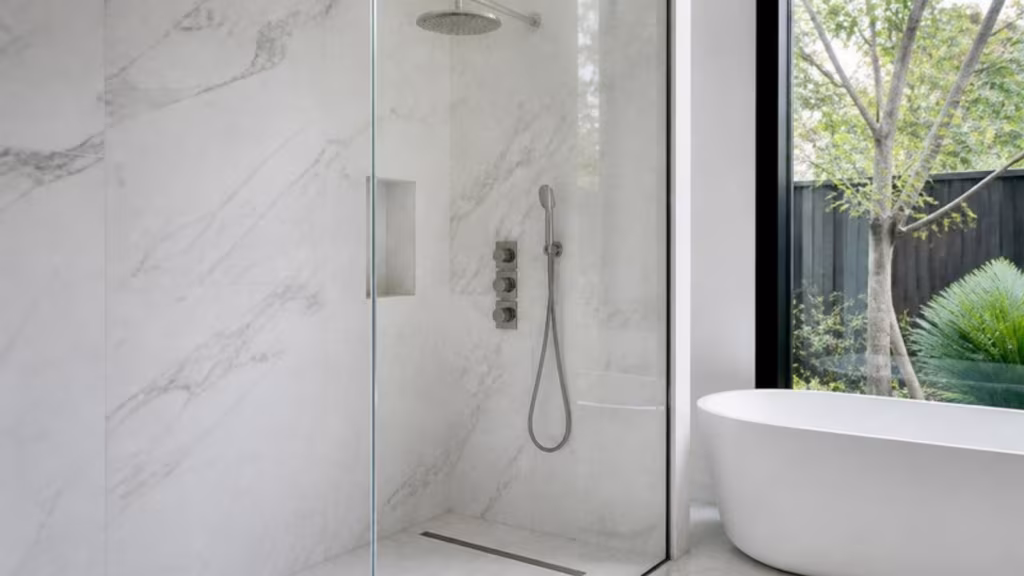 Extra-clear low-iron glass shower screen in a white marble bathroom