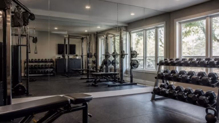 Home gym with a wall clad in large mirror panels
