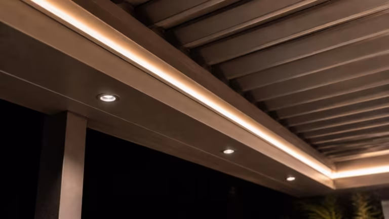 Pergola beam with built-in LED downlights and strip lighting at night