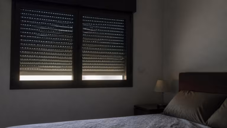Bedroom darkened by a closed electric roller shutter