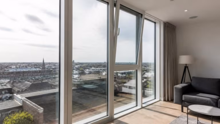 Apartment with tall white tilt and turn windows, one tilted open