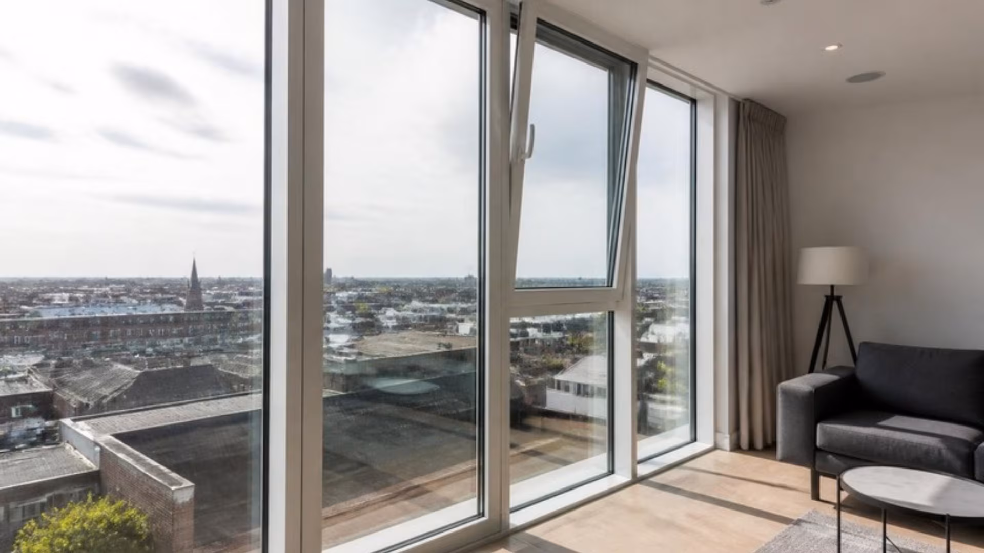 Apartment with tall white tilt and turn windows, one tilted open